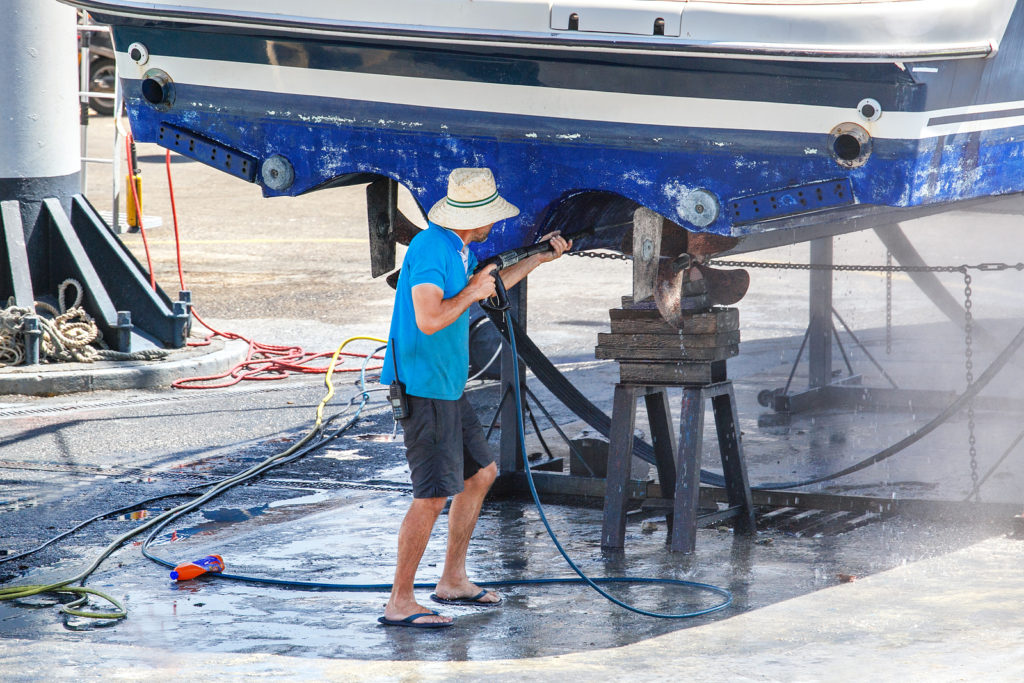 man clean boat with high pressure water